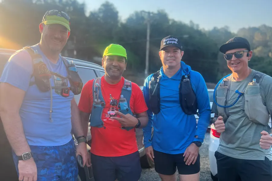Four runners wearing hydration vests before a trail run