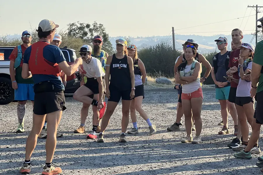 Runners listening to a route briefing before a group trail run