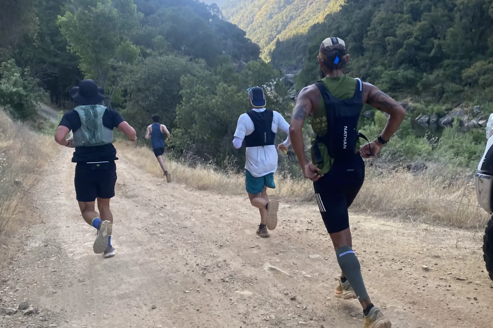 Trail runners descending a dry Auburn canyon toward the American River