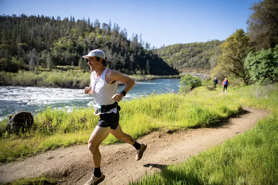 Runner moving along a riverside trail in the American River canyon